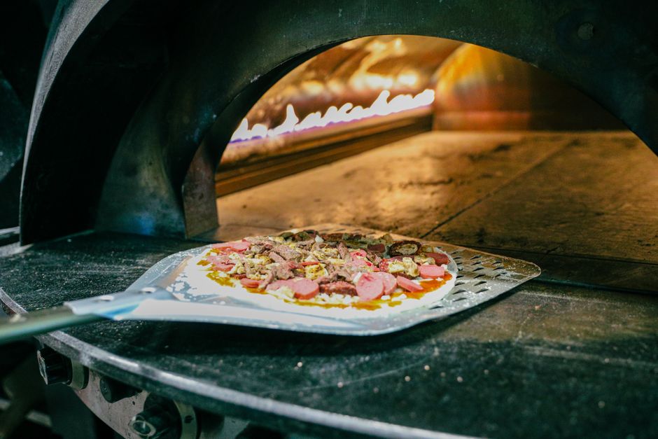 Przygotowanie pizzy w tradycyjnym kamiennym piecu